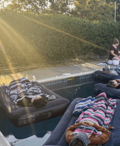 guests resting on personal rafts at sunset during a sound bath