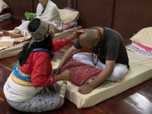 Female Shipibo Shaman treating guest at Ayahuasca retreat center Peru