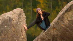 Lauren Walker in a yoga position between two boulders