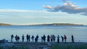 group of people standing at the waters edge