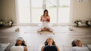 a woman in lotus position reading to a class