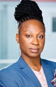 A headshot of a Black person in a blue blazer.