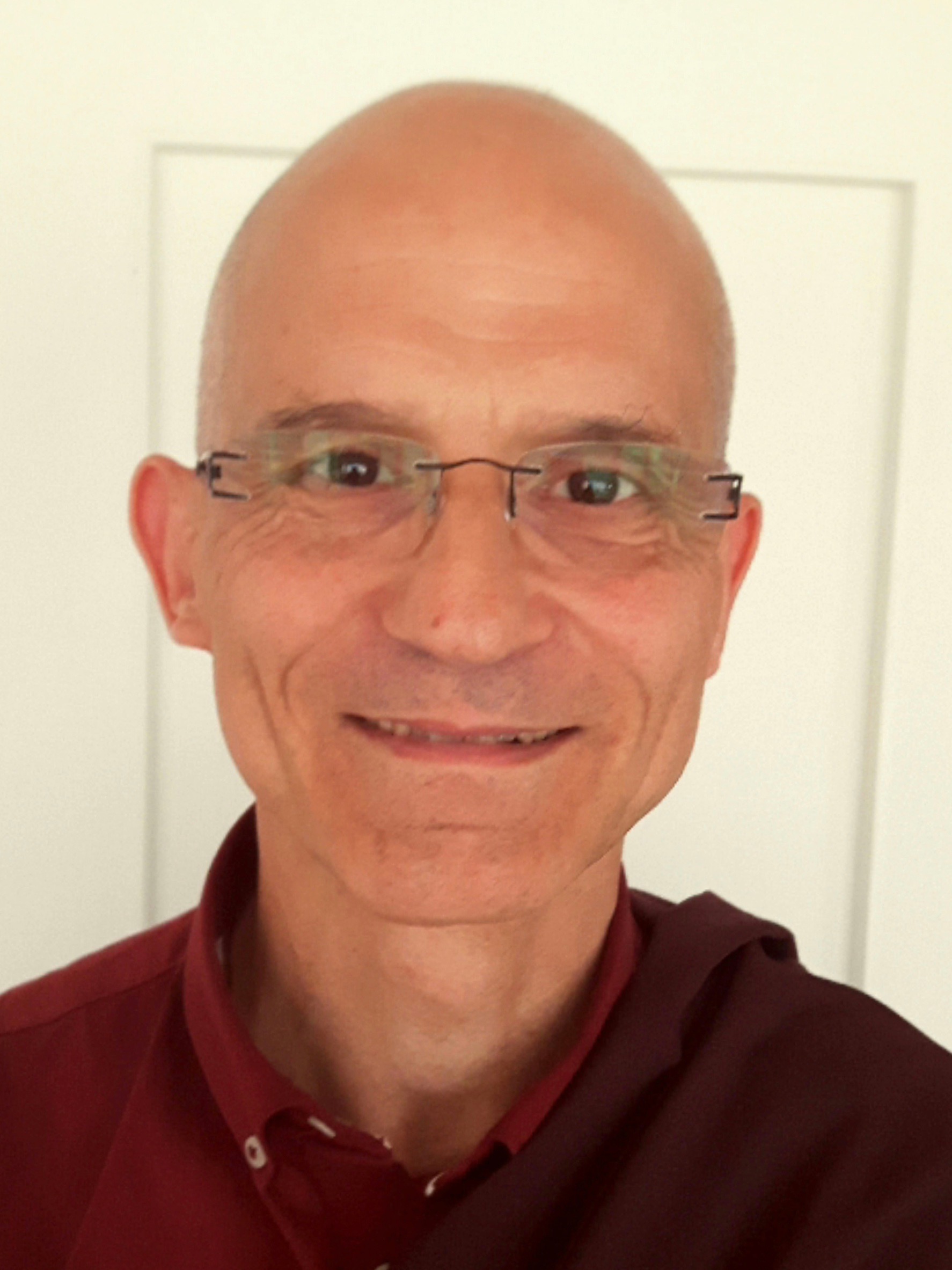 A bald man in glasses and Tibetan lamarobes