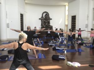 A classroom of yoga students in triangle pose
