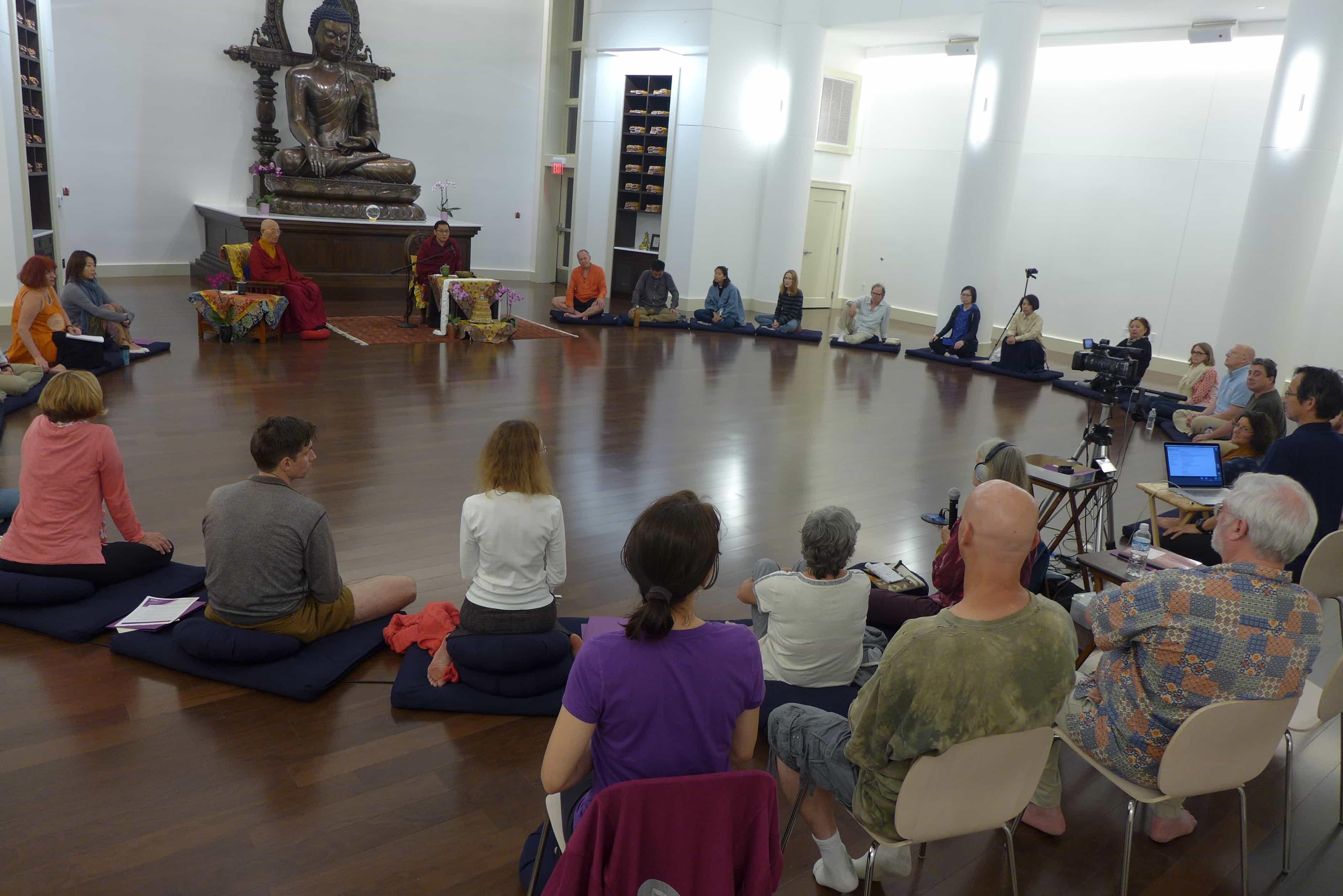 Peopel sitting in a large circle listening to Trungram Gyalwa Rinpoche