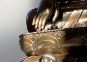 Buddha's fingers touching the ground in a statue