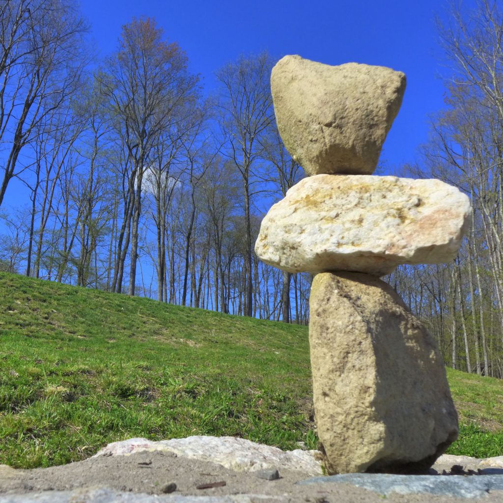 stone mandala on a green hillside