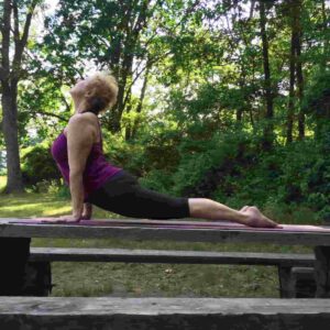 woman in Cobra position in tree-shaded locale