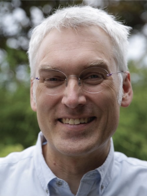 smiling man with white hair and glasses