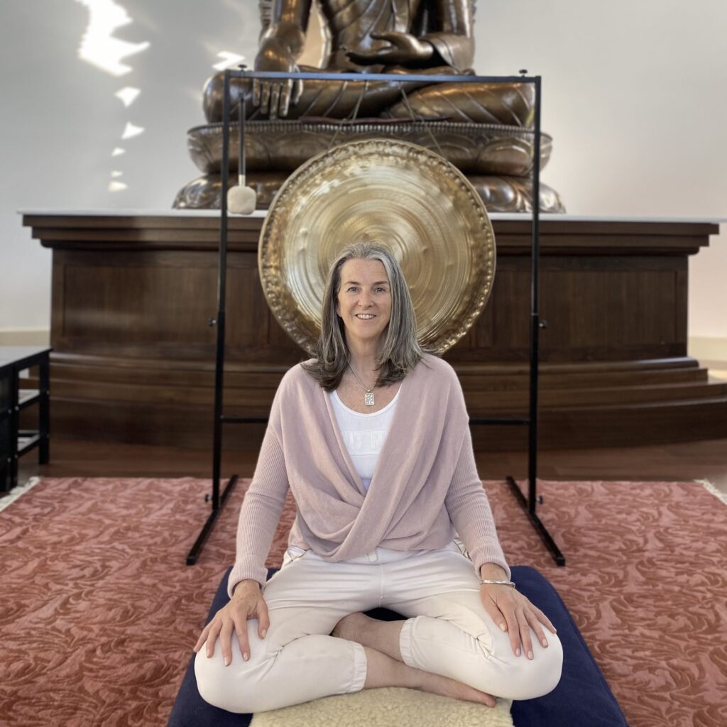 Trish O'Gorman with gong in meditation hall