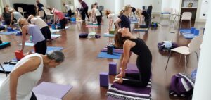 Yoga class with woman in black leotard in camel pose