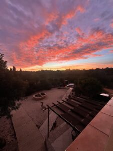 red sunset and clouds overlooking a pagoda and pool in southern portugal at a psilocybin retreat