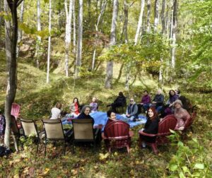 A group of people sitting in the Sanctuary forest in a circle about to meditate.